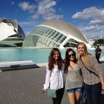 three girls standing in front of round art building