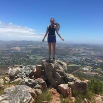 girl standing on top of stack of rocks overlooking land