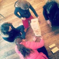four girls playing a stacking game