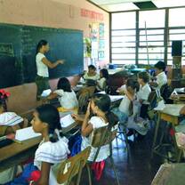group of students inside a classroom listening to their teacher