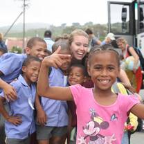 student smiling with young children
