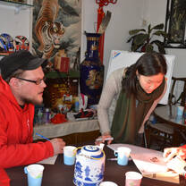 Students look at a paper shown by a man.