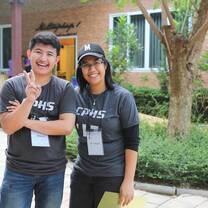 The girl and the boy wearing same shirt standing outside and smiling