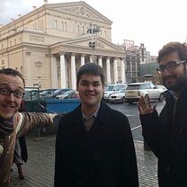 Three men standing outside the building