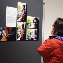 The girl looking at the photos on the wall