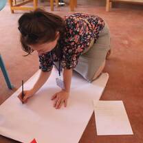 woman writing in a large cardboard