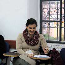 The girl is sitting on her chair while smiling