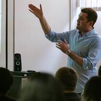 man talking in front of a group of crowd