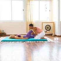 The girl is helping the other girl in stretching