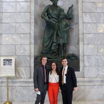 three people took a picture at the statue