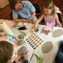 little girl do the art works while the old guy watch him