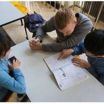 three students in table studying