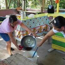 two ladies one is pouring a liquid while the  other one is mixing