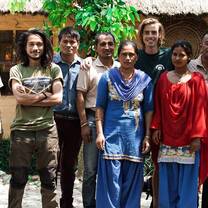 Men posing with two women in traditional costume.