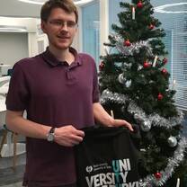 a male student beside christmas tree