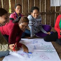 group of women chatting inside a wooden hut
