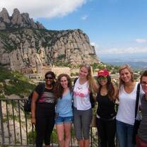people smiling with ocean and mountain in the back 