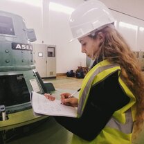 Maria in a Hardhat woman in a Hardhat with a pad of paper taking notes