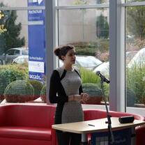 The girl standing in front saying something on the microphone