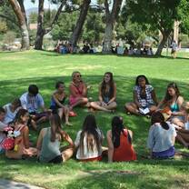 students sitting in a circle on grass 