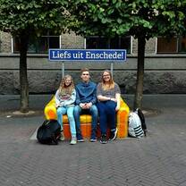 three person seating on the bench
