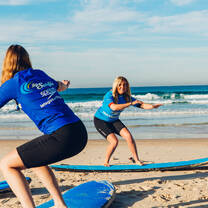 student watching instructor and learning to surf 