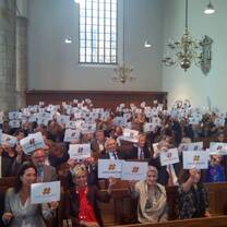 many people sitting holding a paper