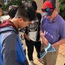 A student sharing family photos with his homestay brother