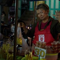Lady selling bananas at a food stall in a busy Market