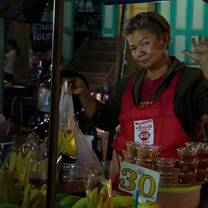 Lady selling bananas at a food stall in a busy Market
