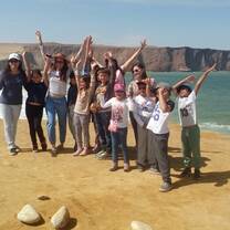 Group of students posing on the a cliff overlooking the ocean in Peru