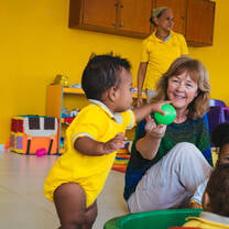 Toddler and senior volunteer playing with a ball