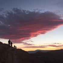 Hikers on a hill in the Atacama desert with sunset in background