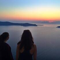 Olivia and Ming looking at a sunset in Santorini