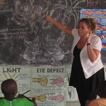 Volunteer teaching in a Ugandan primary school