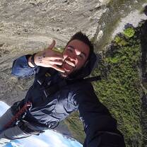 A man smiles at the Camera while jumping 