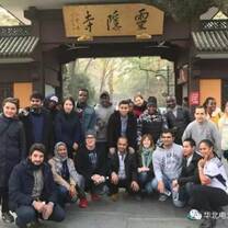 Students smiling outside of a traditional gate 
