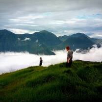 people on top of a hill above the clouds