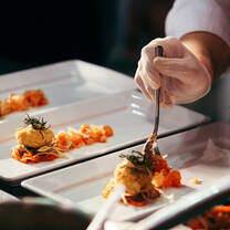 Person fixing dish at a restaraunt