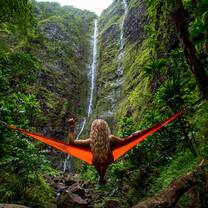 girl in hammack surrounded by green mountains