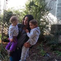 a woman carrying two children