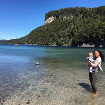 woman caring a baby near a sheashore