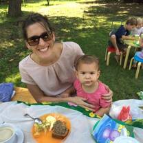 a woman with a little girl having a picnic on a park