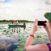 person taking photo of group on boat