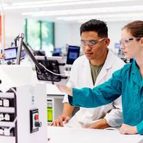 Two people in a lab inspecting a screen