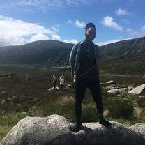 person standing on rock with land behind her 