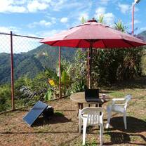 Table with laptop provided by solar energy and mountains on background