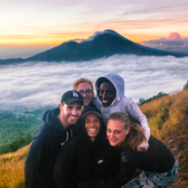 people in front of volcano at sunrise