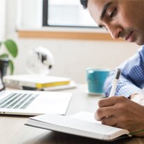 man studying writing in notepad