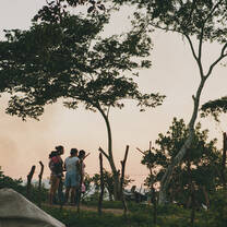 A family looks out over the fence as the sun sets wondering "What comes next?"